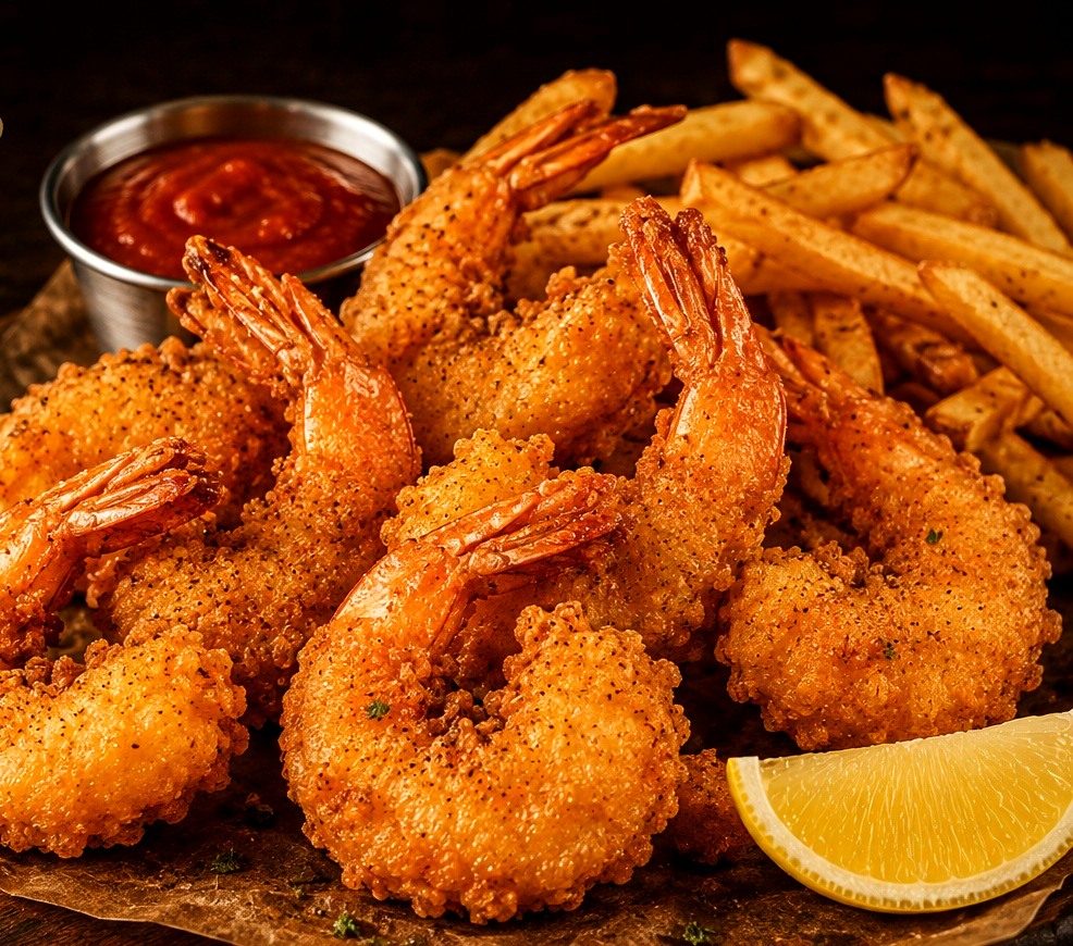 Breaded fried jumbo shrimp with fries, cocktail sauce, and lemon